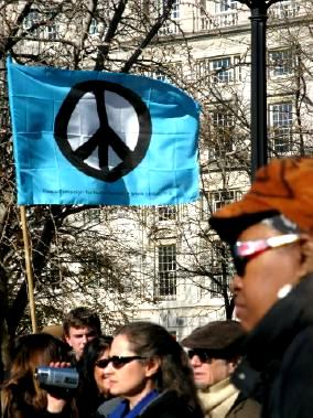 Demonstrators with blue peace-sign banner